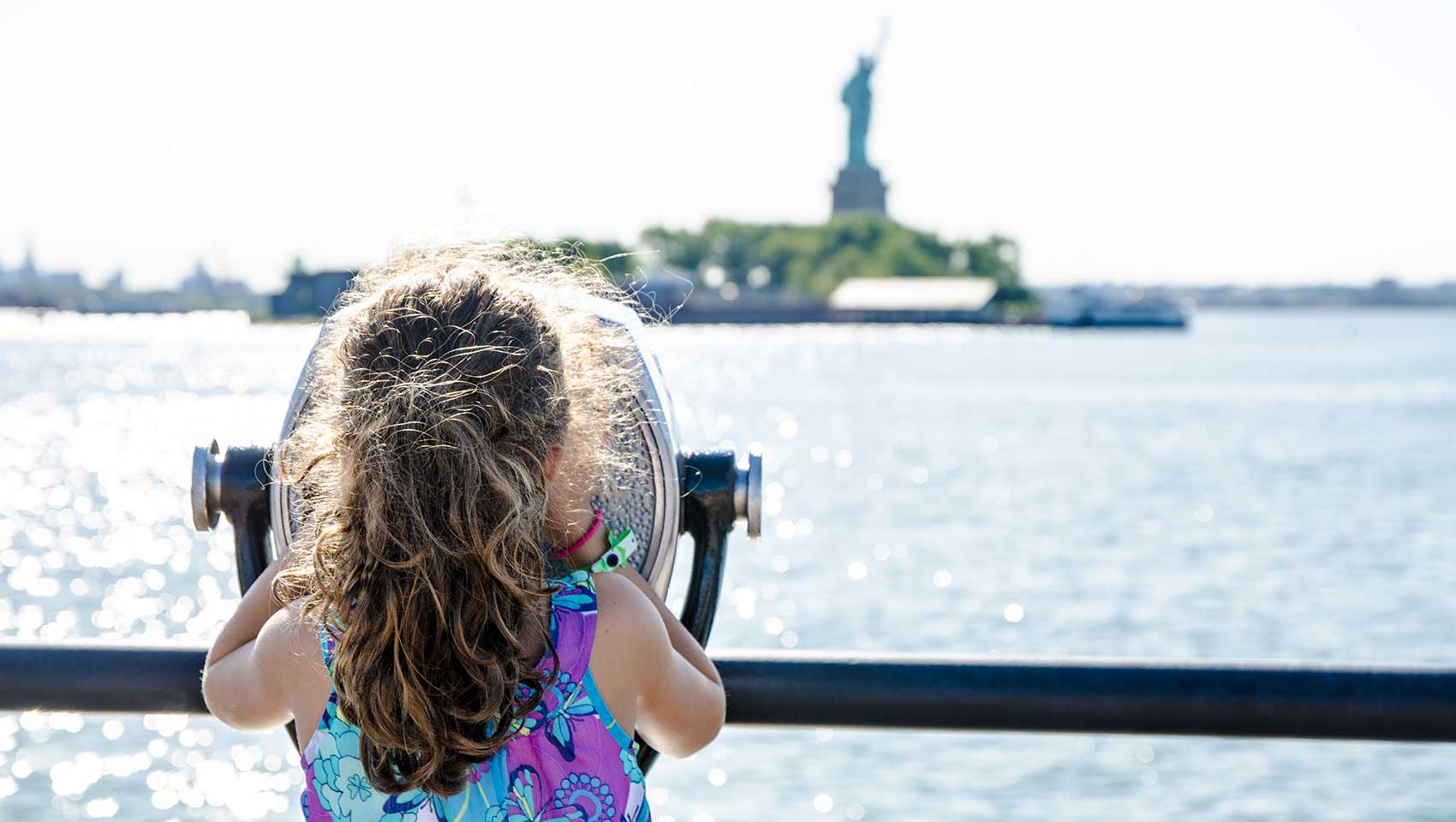 Young child gazing up at the Statue of Liberty outdoors